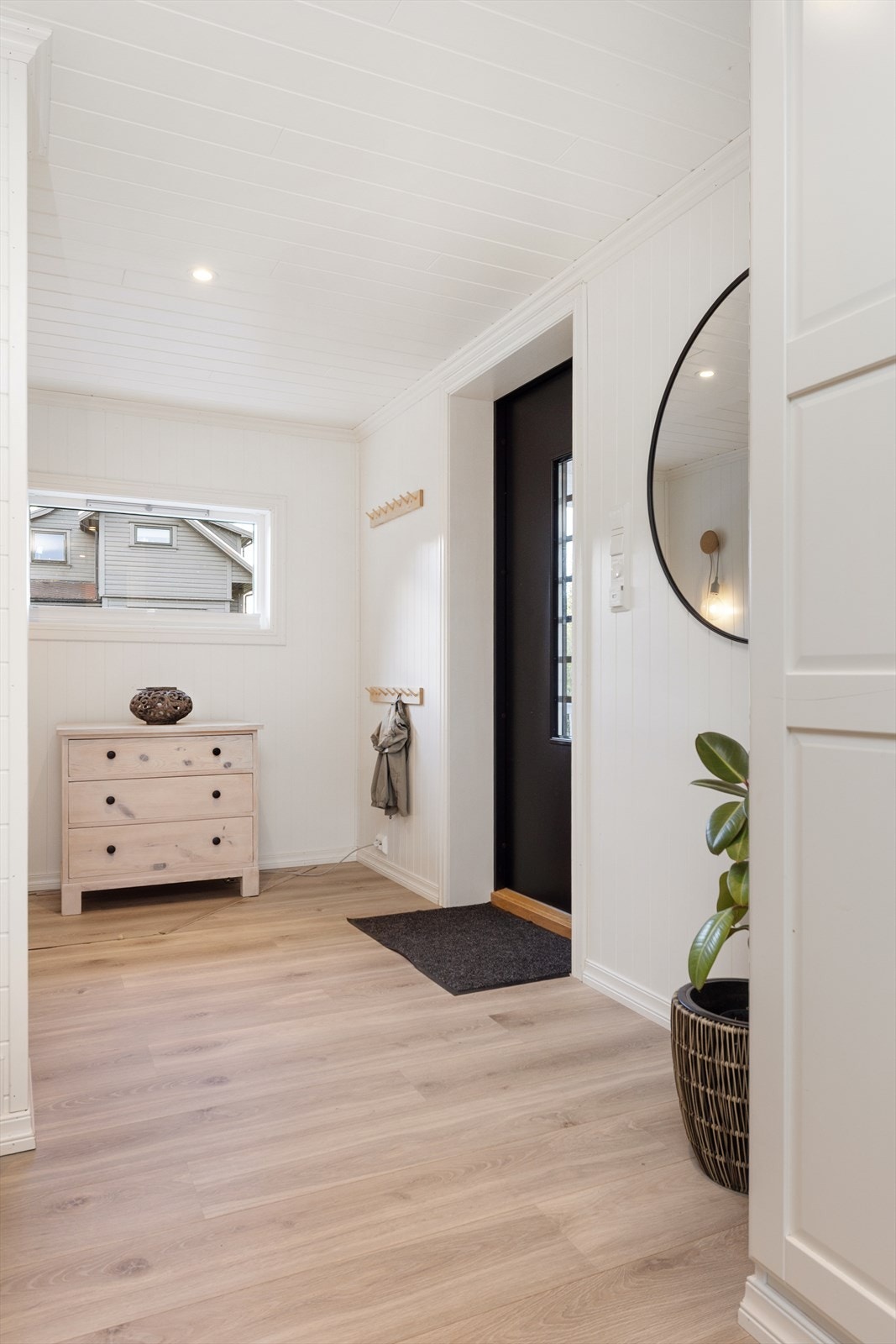 Vindfanget ønsker velkommen inn i boligen og har laminat på gulv og panelplater på veggene. Galleribilde