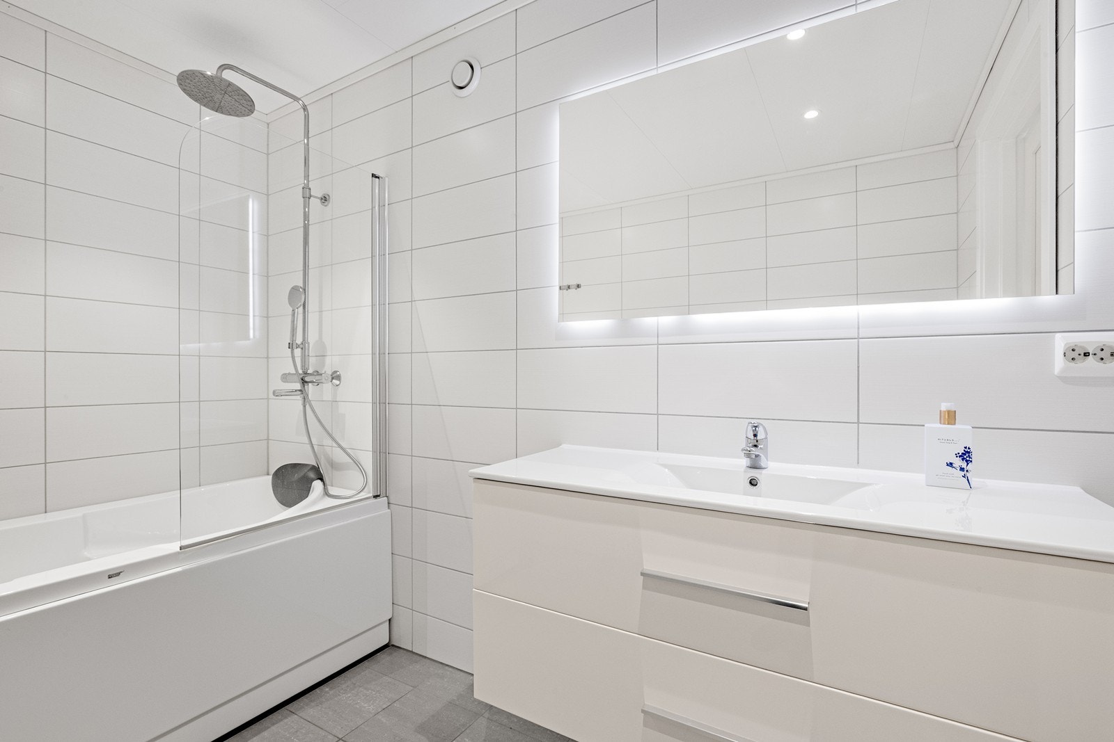 Badet er utstyrt med vegghengt toalett og badekar med dusjvegg i glass. Galleribilde