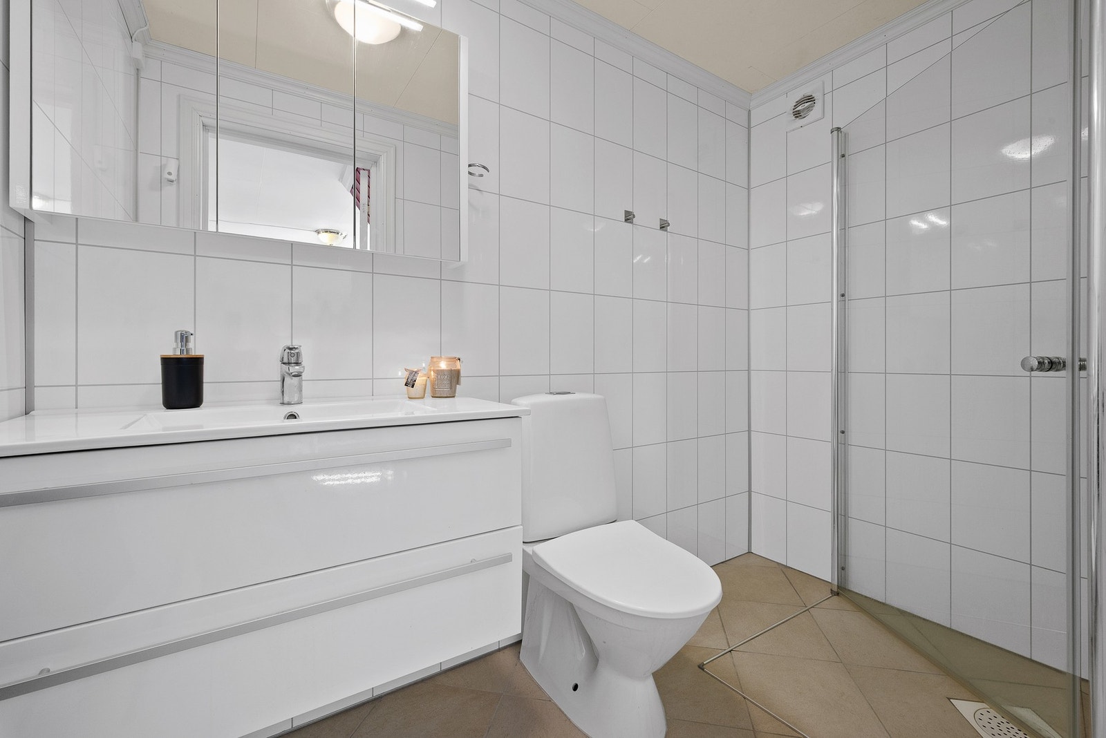 Badet er på 3,5 kvm. og ble pusset opp i 2020. Rommet inneholder baderomsinnredning, dusjhjørne og toalett Galleribilde