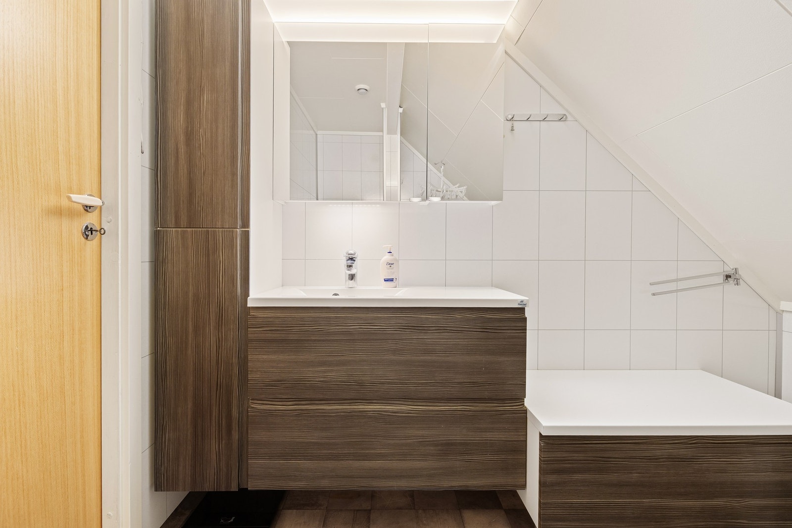 Badet på loftet ble oppgradert rundt 2015 og er innredet med badekar, toalett og stilren baderomsinnredning Galleribilde