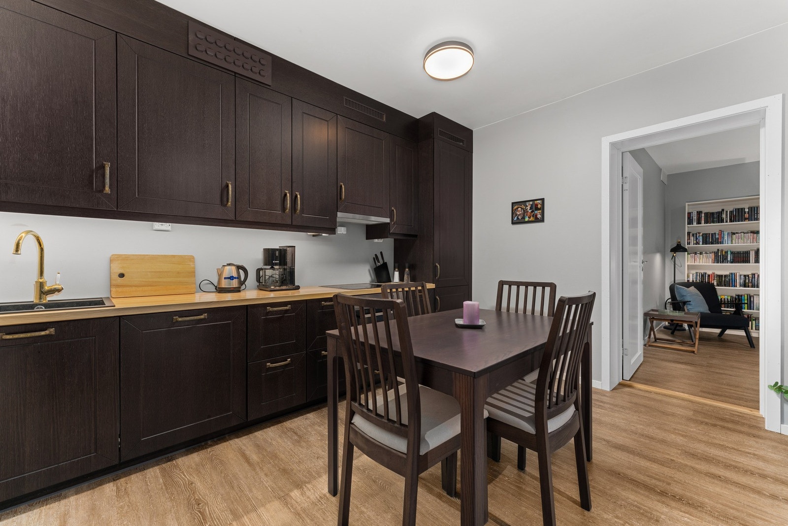 Kjøkkenet fremstår moderne og stilfullt, med mørke profilerte fronter som gir en elegant kontrast til de lyse flatene. Galleribilde