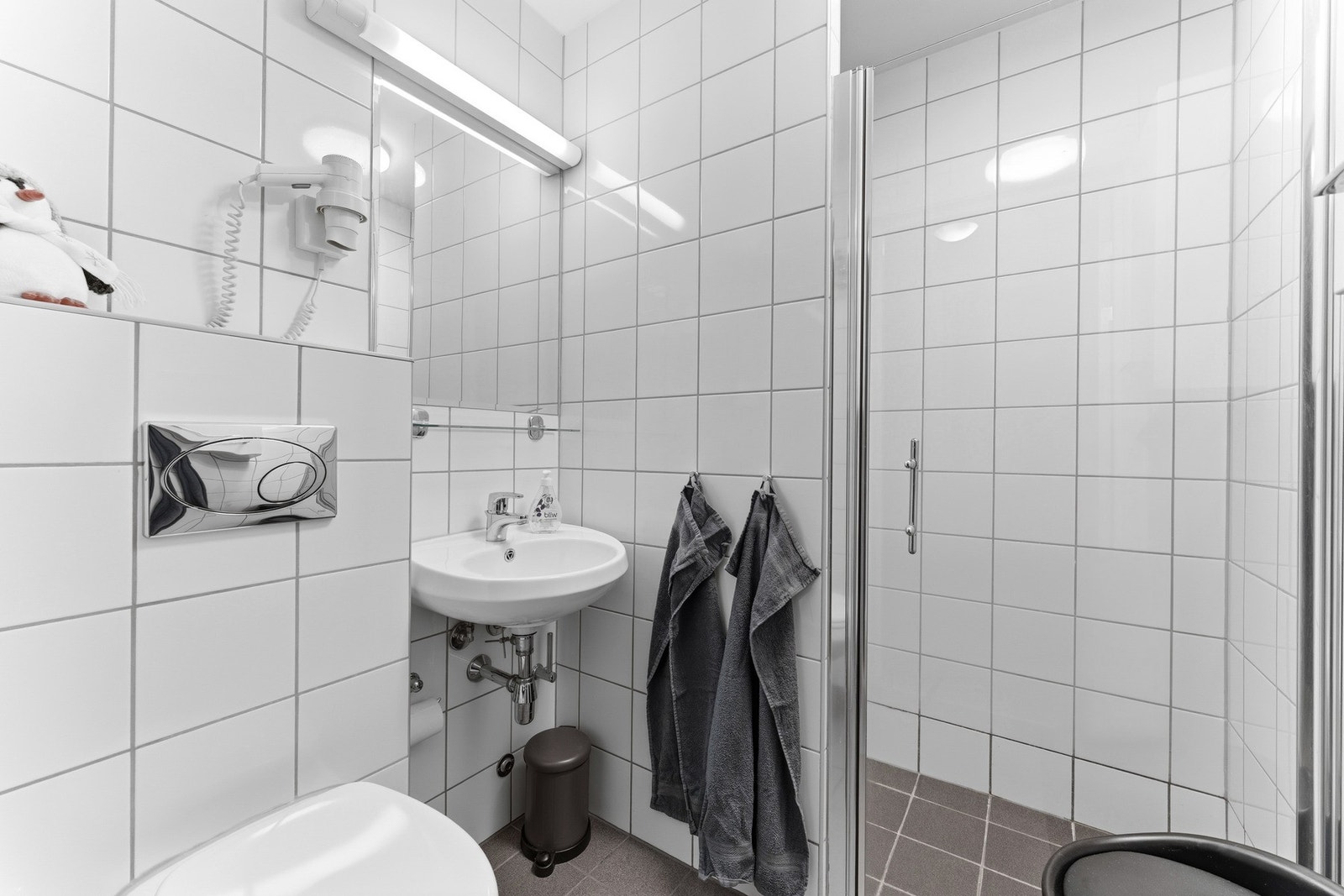 Leiligheten har to like bad med flislagte gulv, elektriske varmekabler, servant, vegghengt toalett og dusjløsning med dusjvegger. Begge badene har mekanisk avtrekk. Galleribilde
