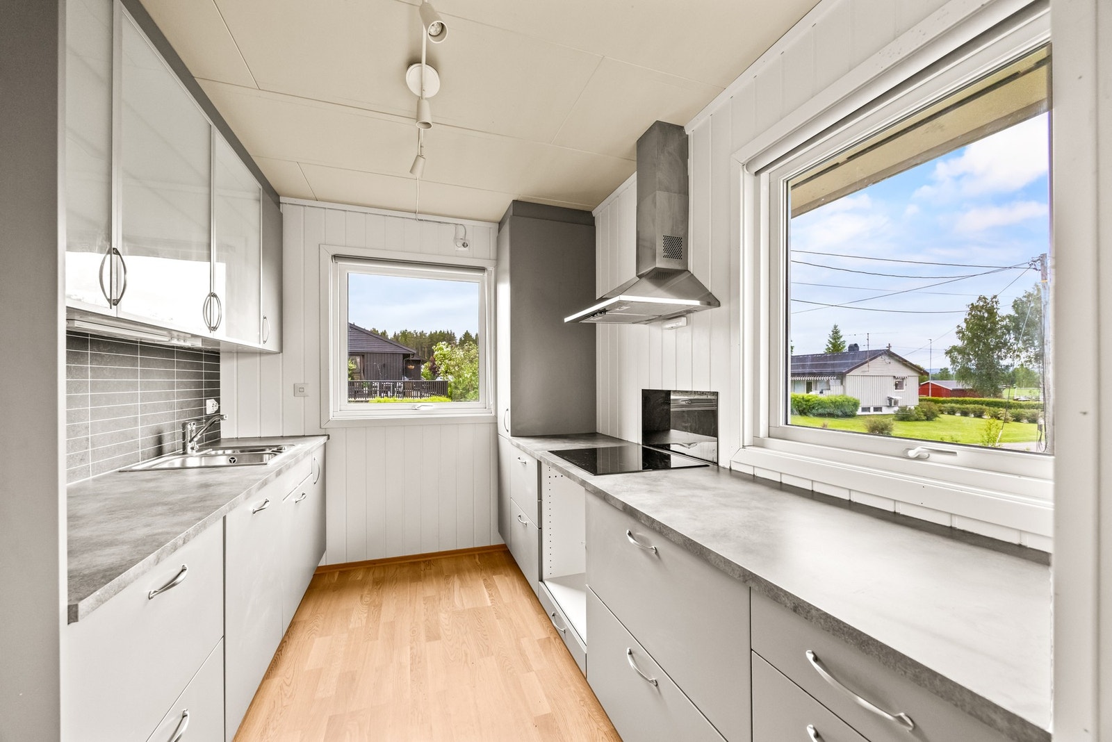 Kjøkkenet er oppgradert i nyere tid og har en glatt grå utforming med benkeplate i laminat, skyllekum og ett-greps armatur. Galleribilde