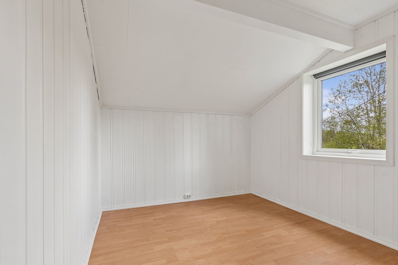 Det ene av boligens to soverom. Rommet har laminatgulv og panel på veggene. Galleribilde