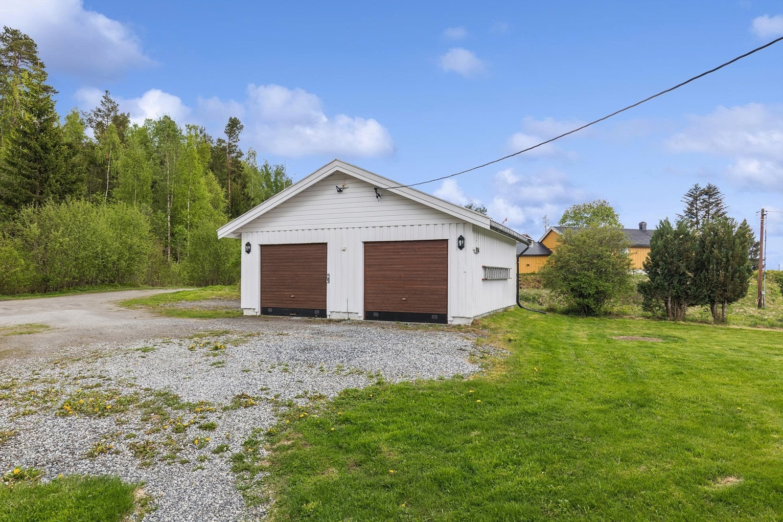Frittstående dobbelgarasje fra 2000 med støpt betonggulv og to separate porter. Galleribilde