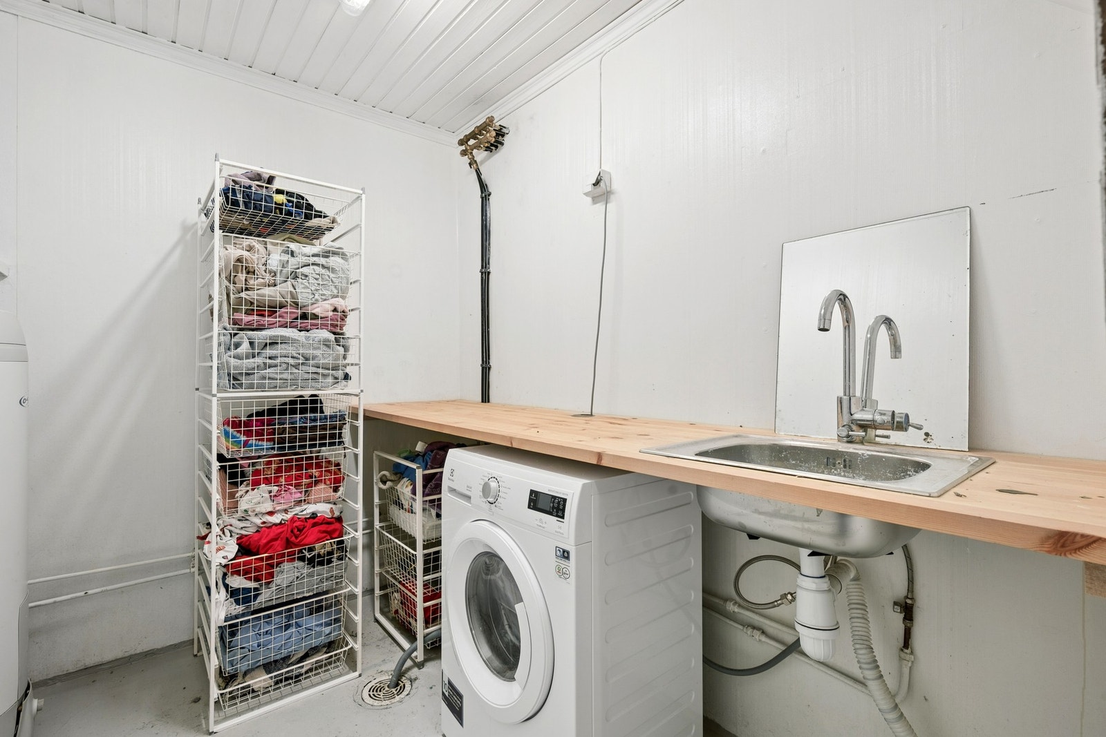 Praktisk vaskerom i kjelleren med opplegg for vaskemaskin og utslagsvask. Galleribilde