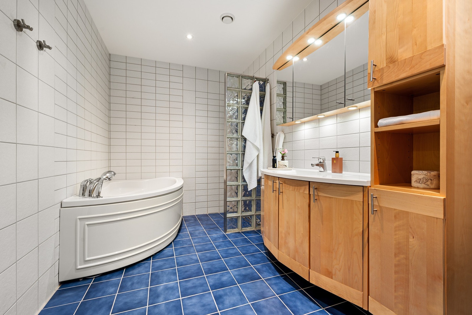 Badet er lyst og godt med downlights i tak i tillegg belysning i baderomsinnredning Galleribilde
