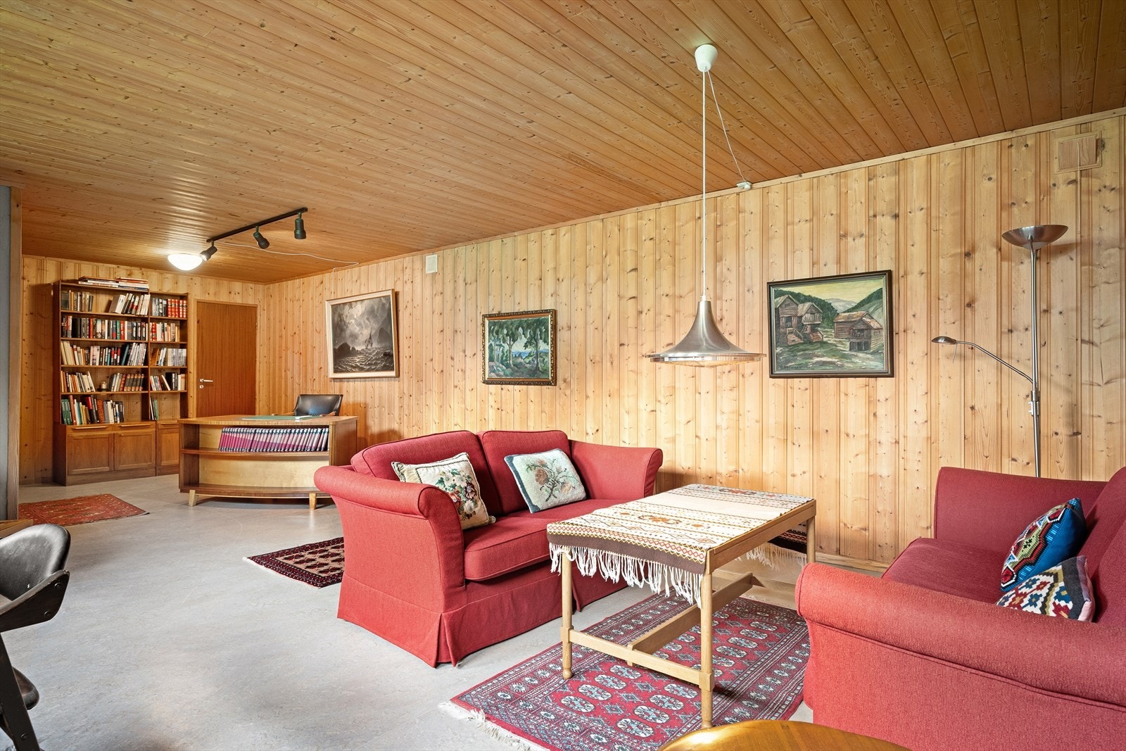 Romslig kjellerstue med panel på vegger og tak. Galleribilde