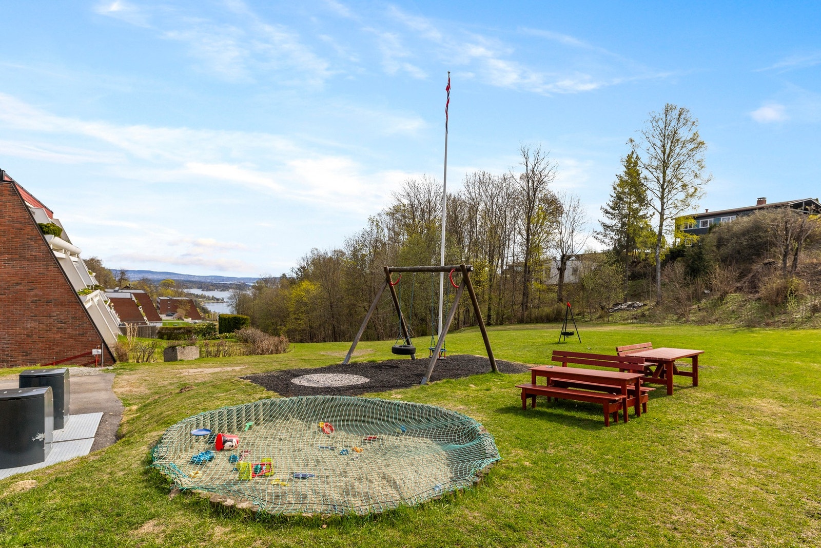 Her med sandkasse, huskestativ og klatrestativ. Galleribilde