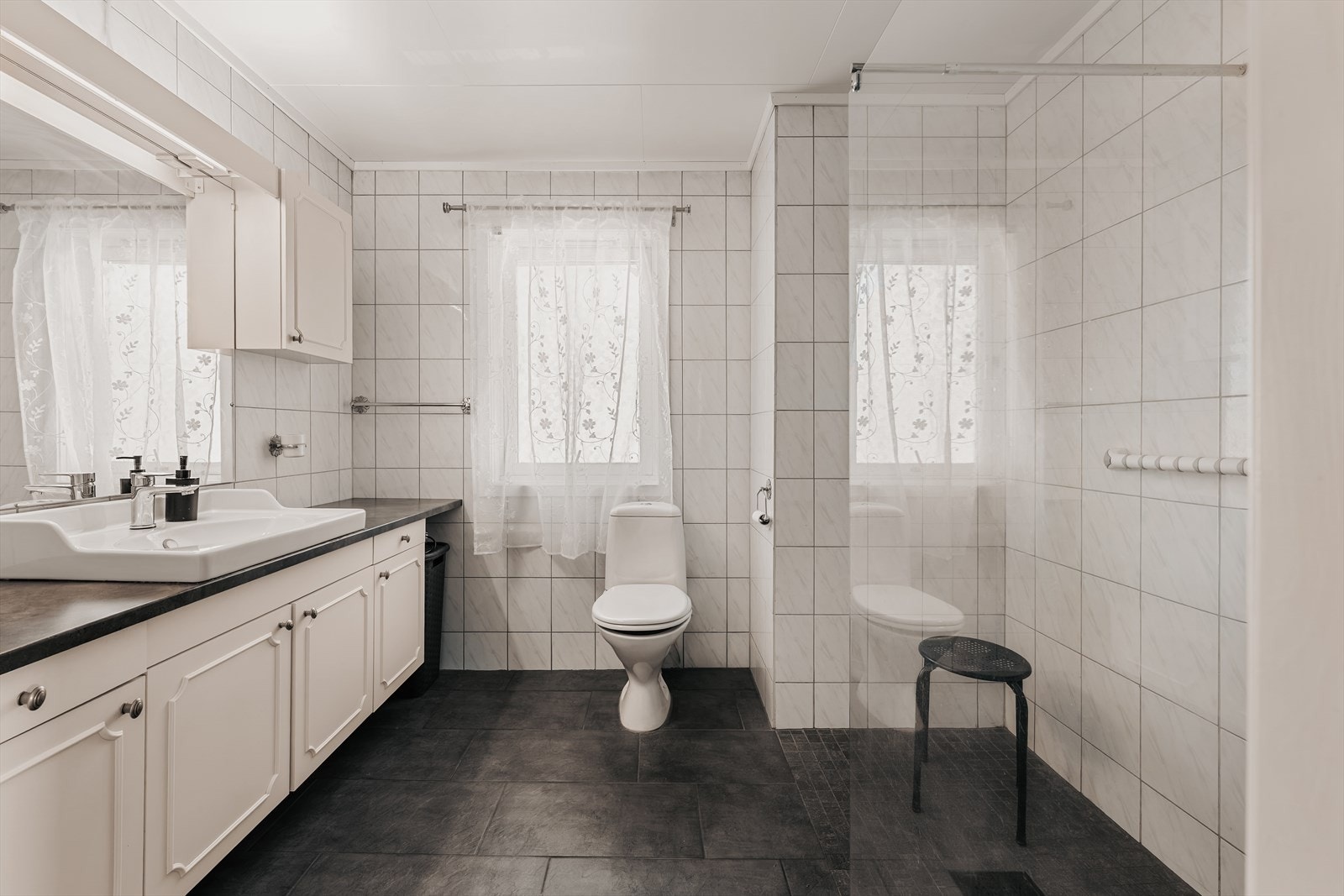 Pent, flislagt bad med gulvvarme fra 2022. Badet er innredet med servantinnredning, gulvmontert toalett og dusjløsning. Galleribilde