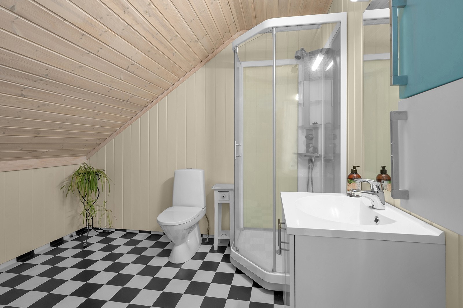 Badet i loftsetasjen har vinylbelegg på gulv og malte panelplater på vegger. Galleribilde