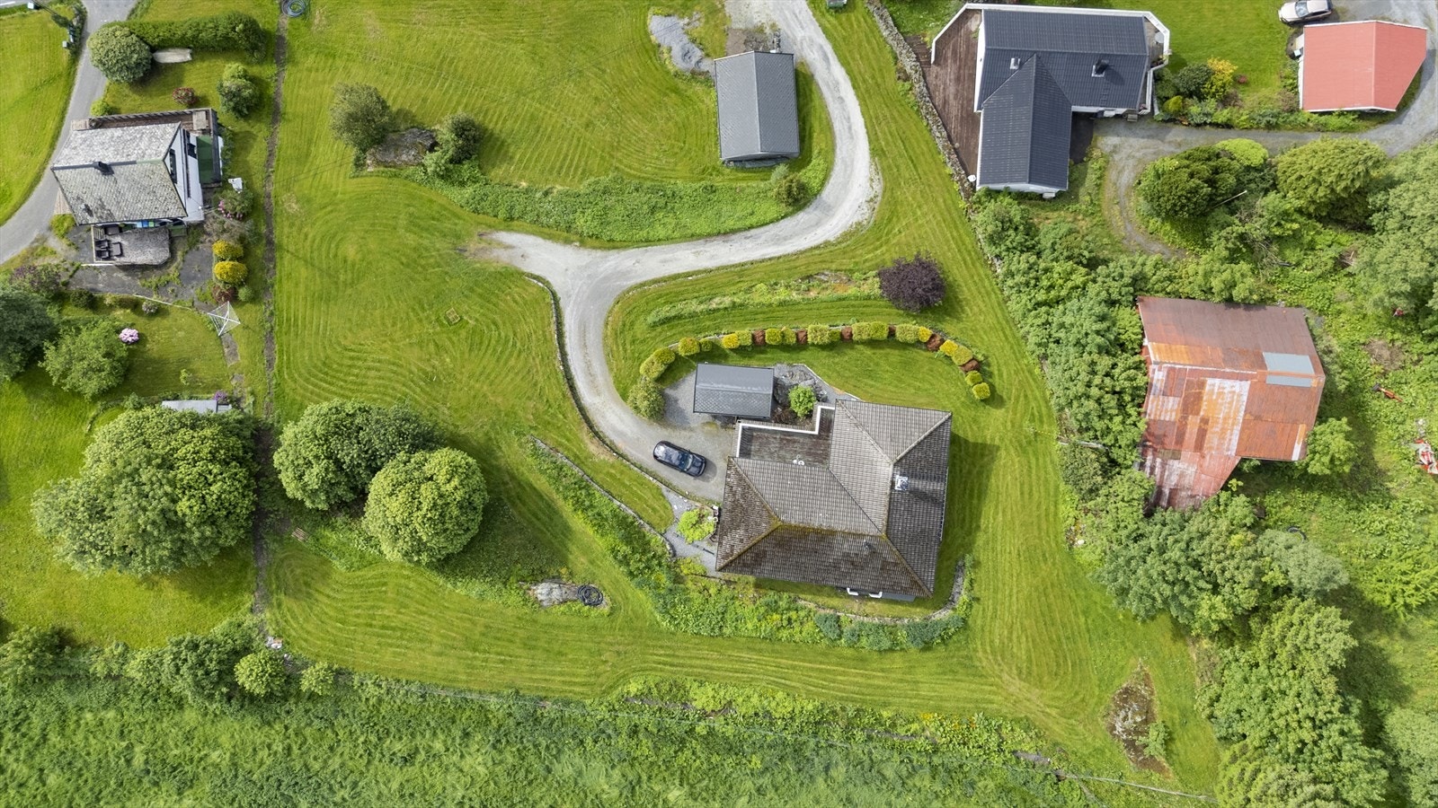 Tomta er pent opparbeidd med støttemurar i naturstein og betong. Galleribilde