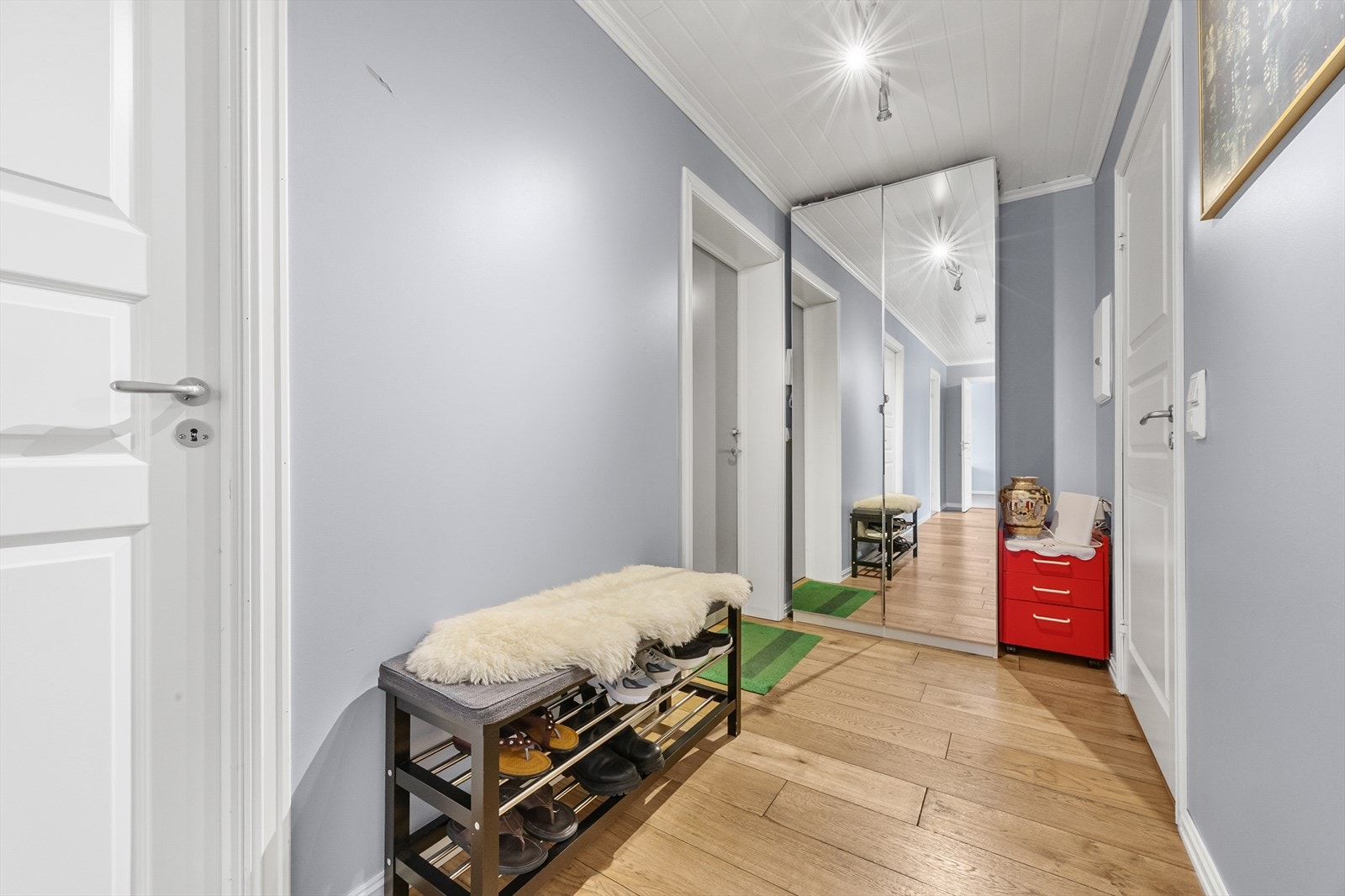 En innbydende entré med parkettgulv og god plass til å henge fra seg klær og sette fra seg sko. Galleribilde