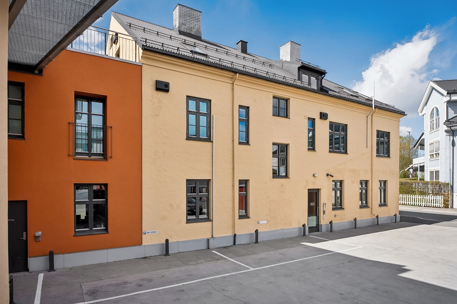Adkomst til leiligheten via felles trapperom i den asfalterte gårdsplassen. Galleribilde