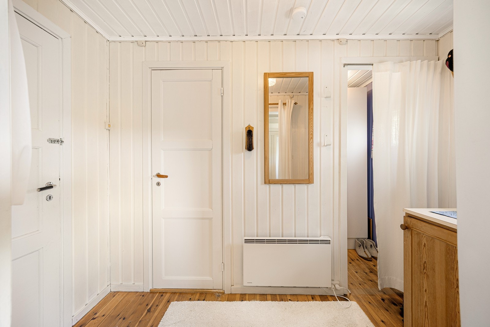 Entréen har lysmalte vegger og et gyllent, originalt heltregulv. Det er god plass til knaggrekker, skohyller og kommoder. Galleribilde