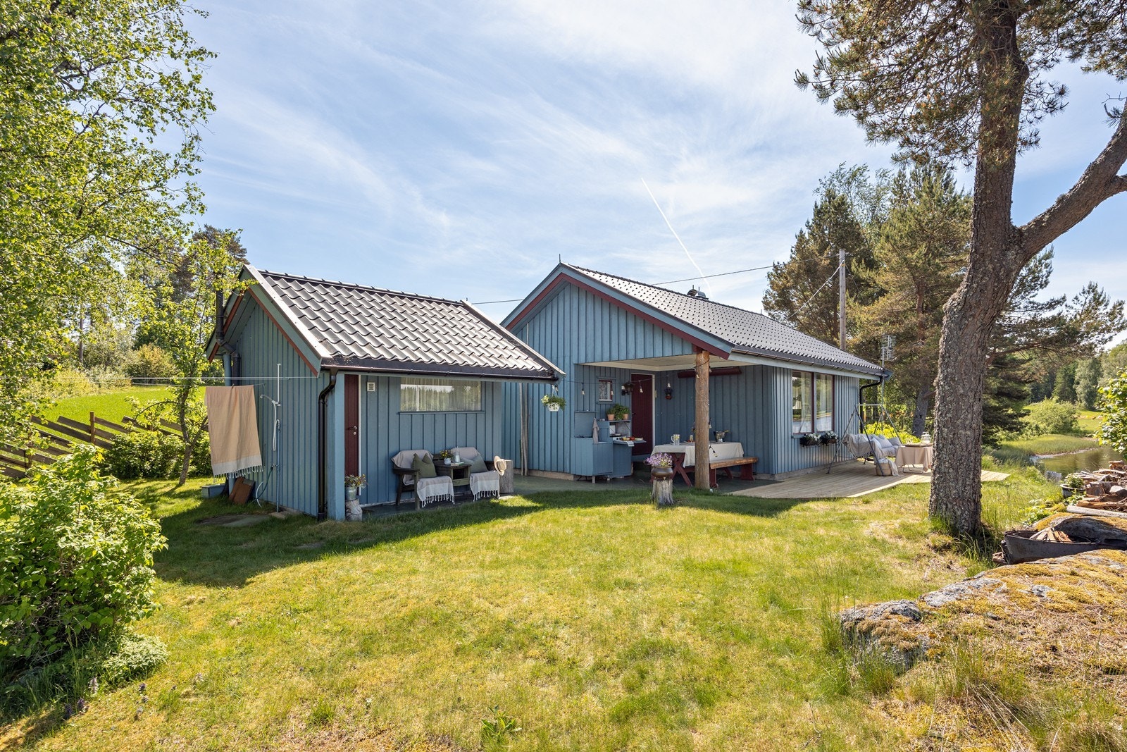 På eiendommen ligger både hytte og anneks. Langs den nordvestvendte hytteveggen er det en romslig markterrasse fra 2026. Galleribilde