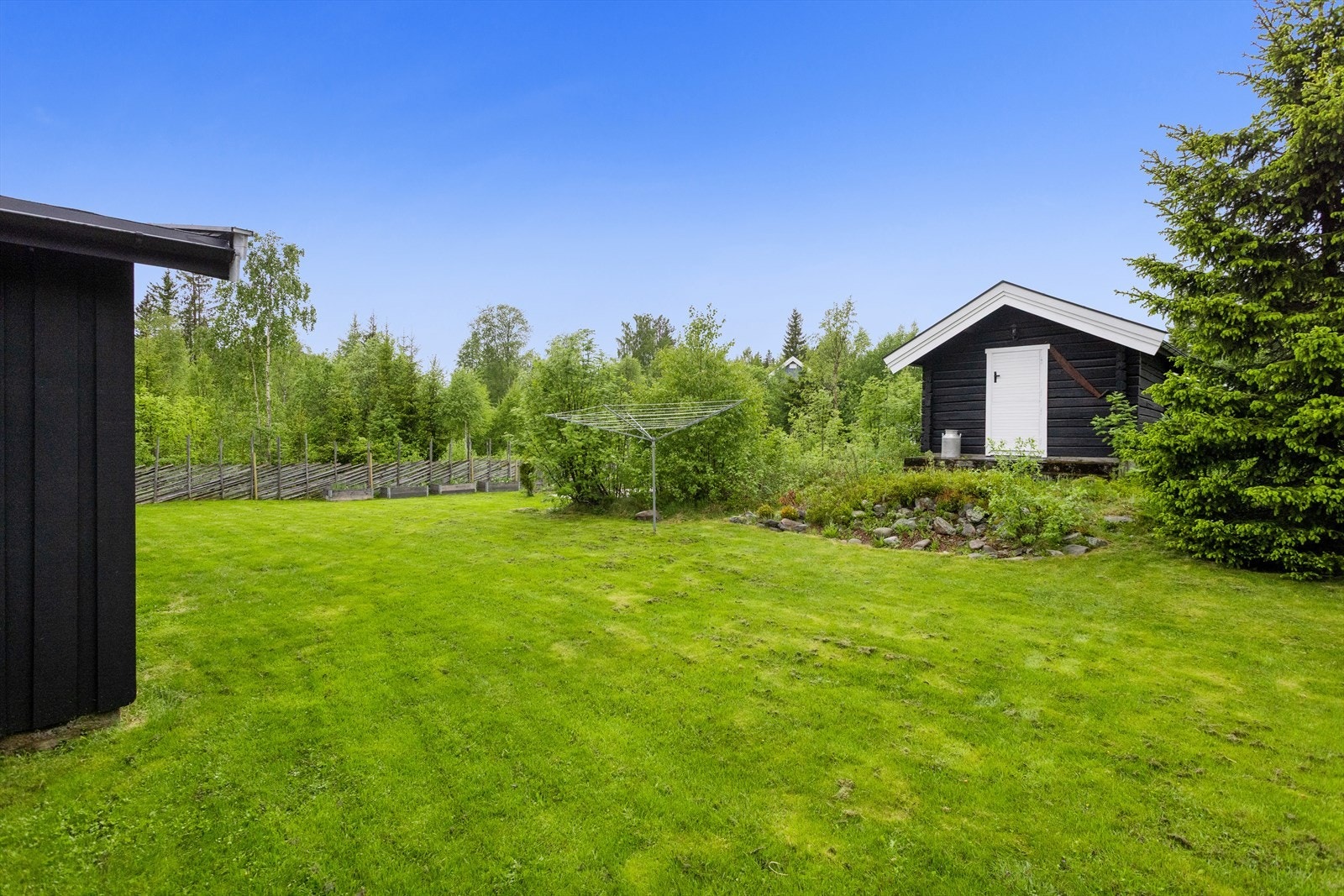 Et pent opparbeidet uteområde med store grøntarealer, og enda et frittstående anneks/uthus skaper en lun og helhetlig ramme rundt eiendommen. Galleribilde