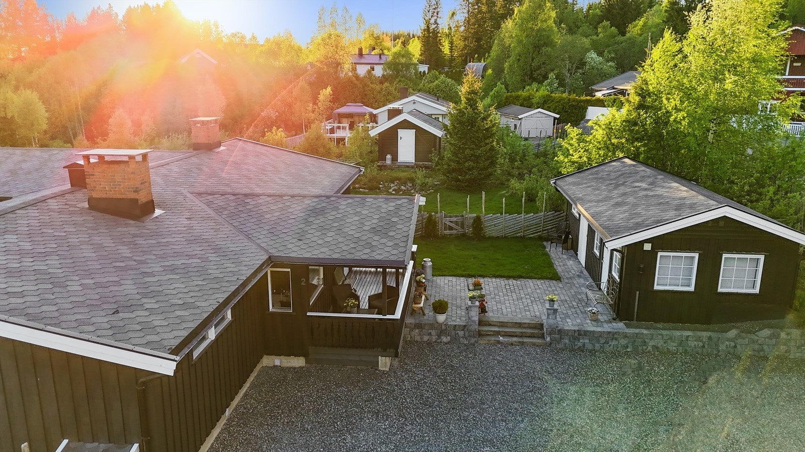 Oversiktsbilde som viser boligens gode plassering på tomten med romslige uteområder og hyggelige solforhold. Galleribilde