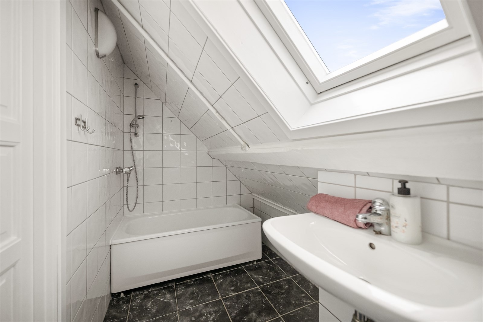 Badet på loftet er utstyrt med badekar, og et takvindu gir godt med naturlig lys. Galleribilde