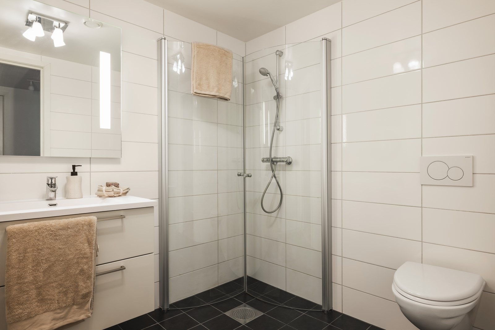 Innredningen består av en vegghengt seksjon med servant og skuffer som gir gode oppbevaringsmuligheter. Videre har badet vegghengt toalett og praktisk dusjhjørne. Galleribilde