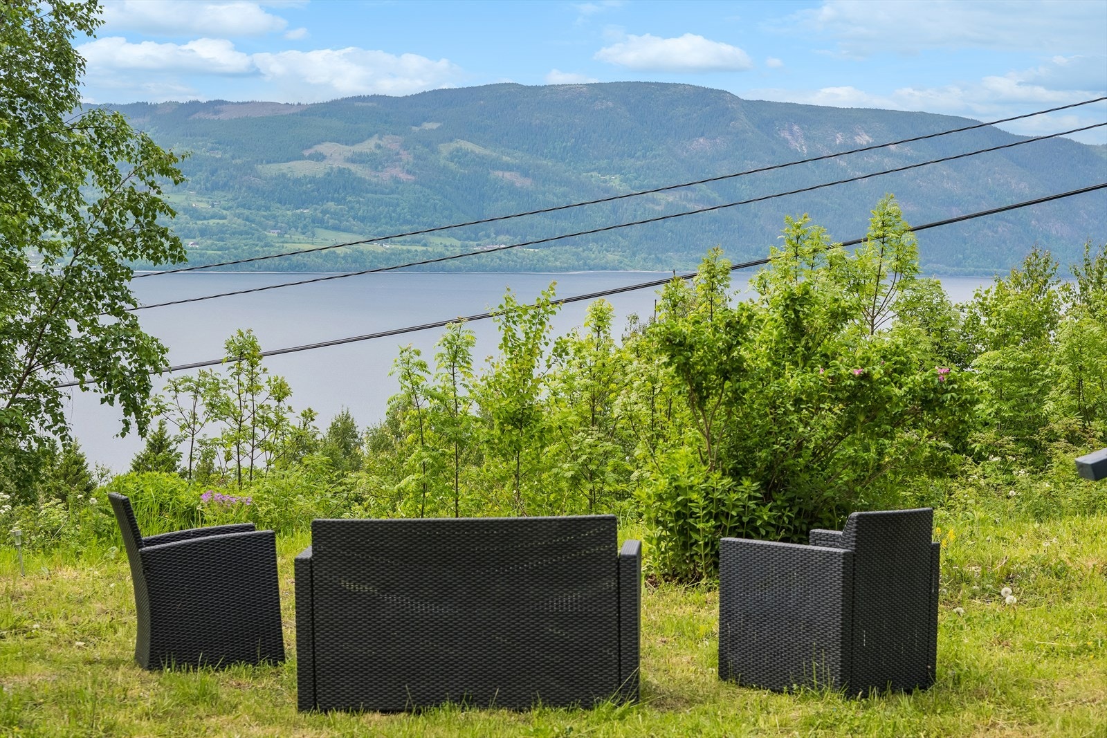 Fra den lett skrående hagetomten er det utsikt over landskapet og Mjøsa. Galleribilde