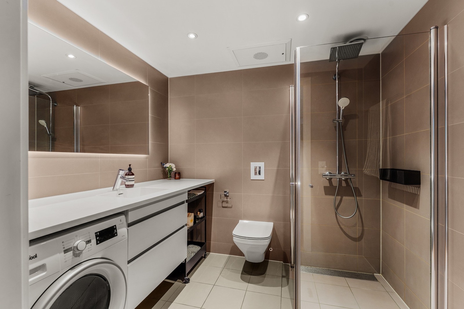 Boligen har et lekkert, romslig bad fra byggeår. Overflatene på badet er flislagt - beige fliser på gulv og veggene, samt gulvvarme og downlights. Galleribilde
