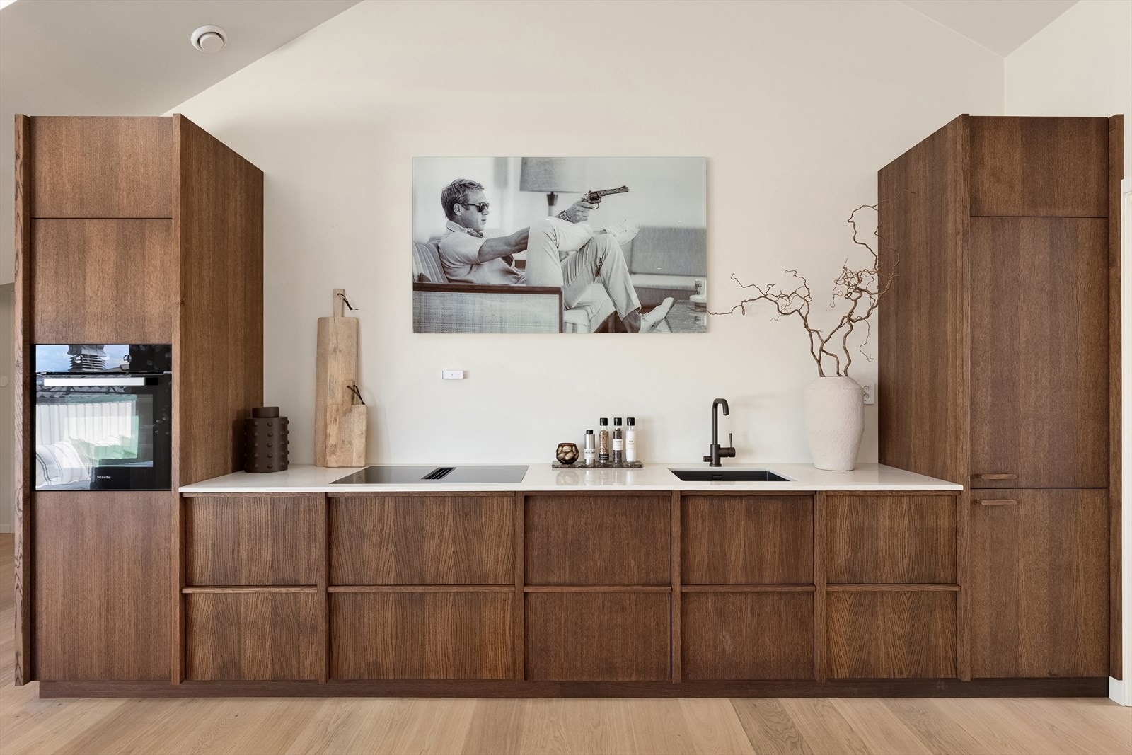 Rålekkert moderne kjøkken fra 2026 levert av møbelsnekker. Diverse MIELE hvitevarer inkludert MIELE stekeovn, planlimt MIELE platetopp med avtrekk i benk, underlimt vask med bronze-armatur, samt integrert kjøl-/fryseskap fra MIELE. Galleribilde
