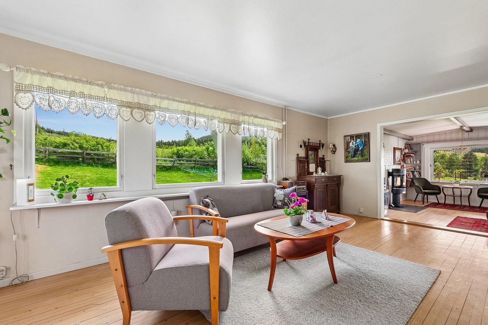 Den ene av boligens to stuer har god plass til sofagruppe og utsyn mot hagen. Galleribilde