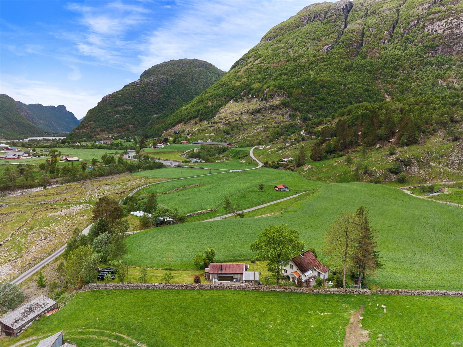 Eiendommen ligger på en liten høyde i et svakt skrånet terreng. Galleribilde