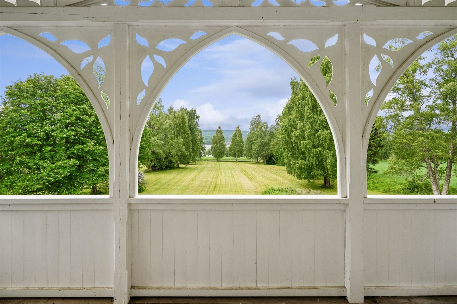 En lun og skjermet uteplass med panoramautsikt over hagen. Galleribilde