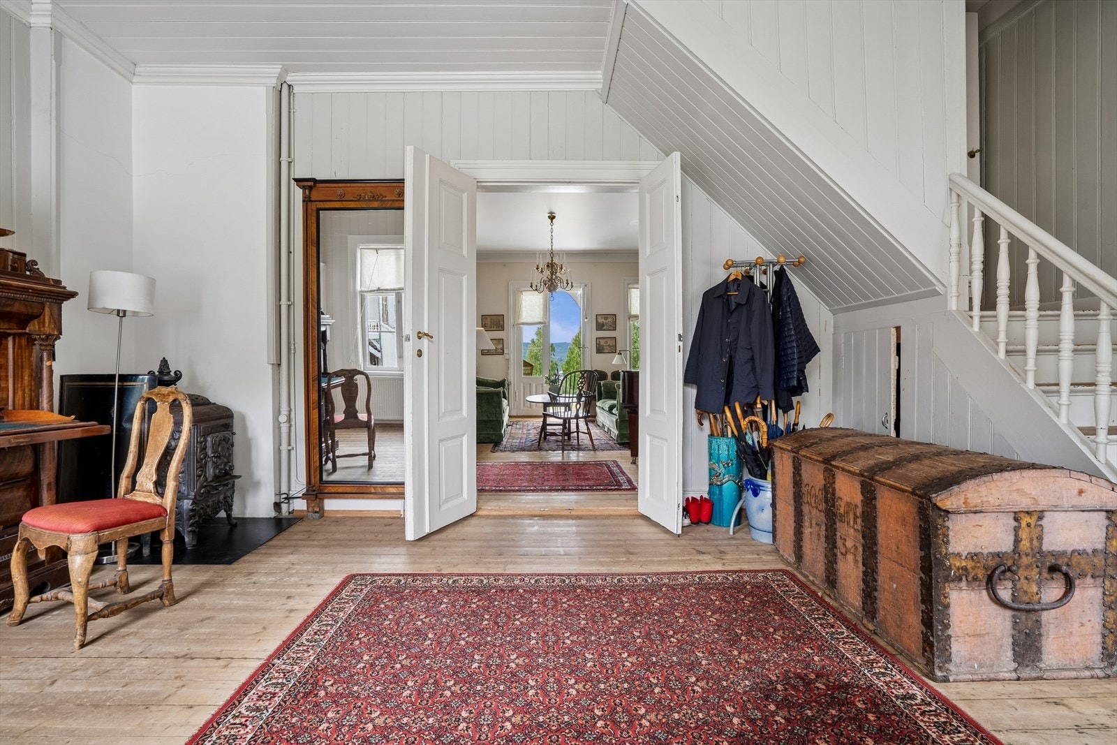 Romslig entré med originale, slipte tregulv og tofløyede dører som åpner opp mot stuene. Galleribilde