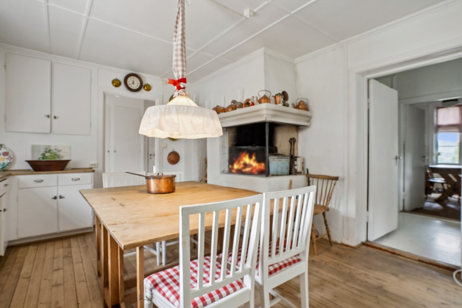 Den åpne, plassmurte peisen på kjøkkenet gir både varme og en samlende atmosfære. Galleribilde