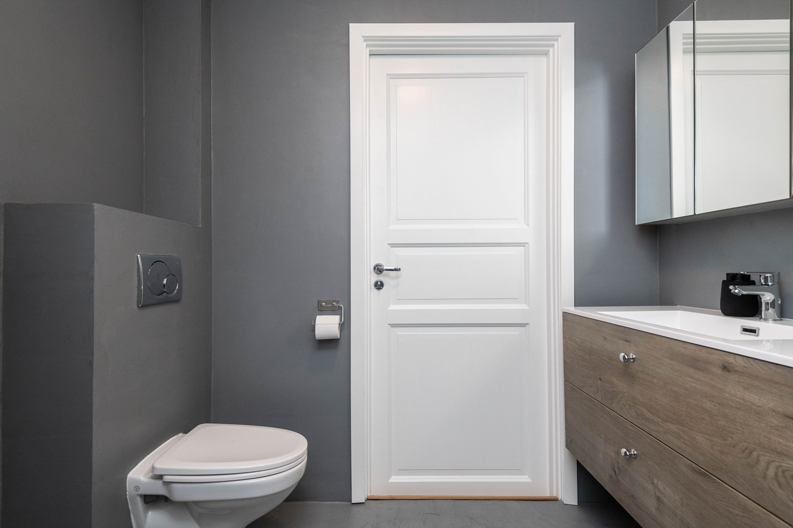 Badet har innredning med mikrosement på veggene og gulv, samt vegghengt toalett. Galleribilde