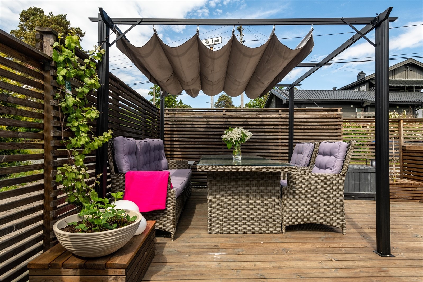 Skjermet terrasse med sittegruppe og plantekasser gir en hyggelig atmosfære for utendørsaktiviteter. Galleribilde