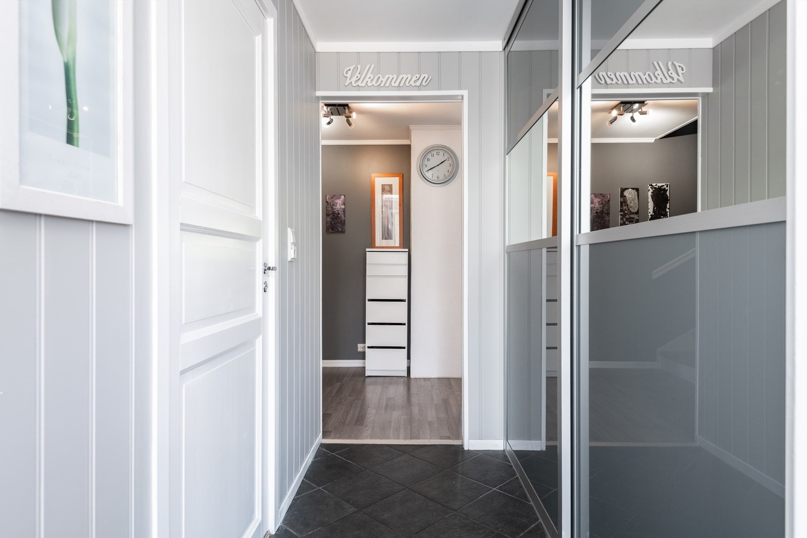 Skyvedørsgarderobe gir god oppbevaringsplass i entréen, hvor gulvet er belagt med fliser. Galleribilde