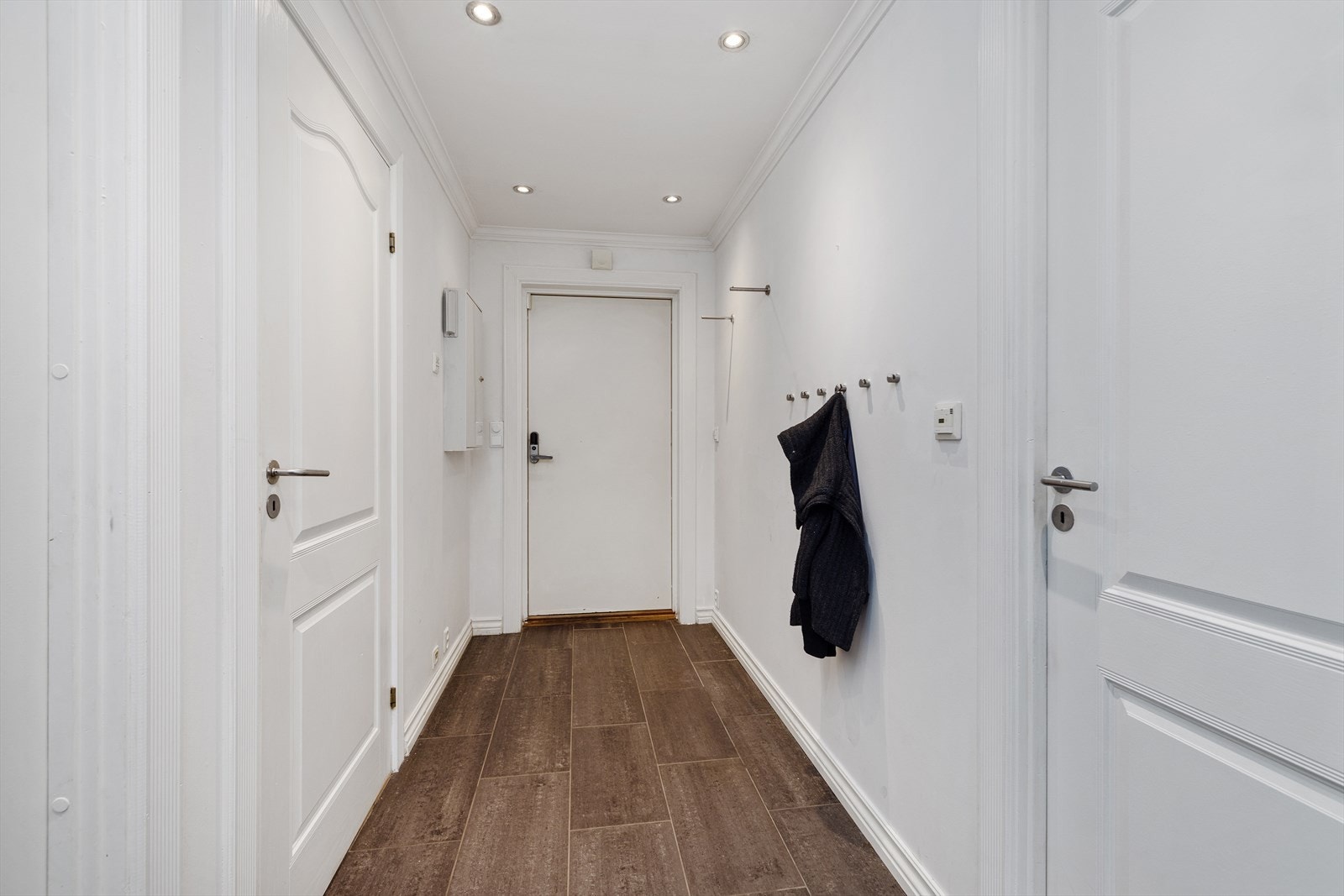 Entré med flislagt gulv og ytterdør utstyrt med kodelås. Galleribilde