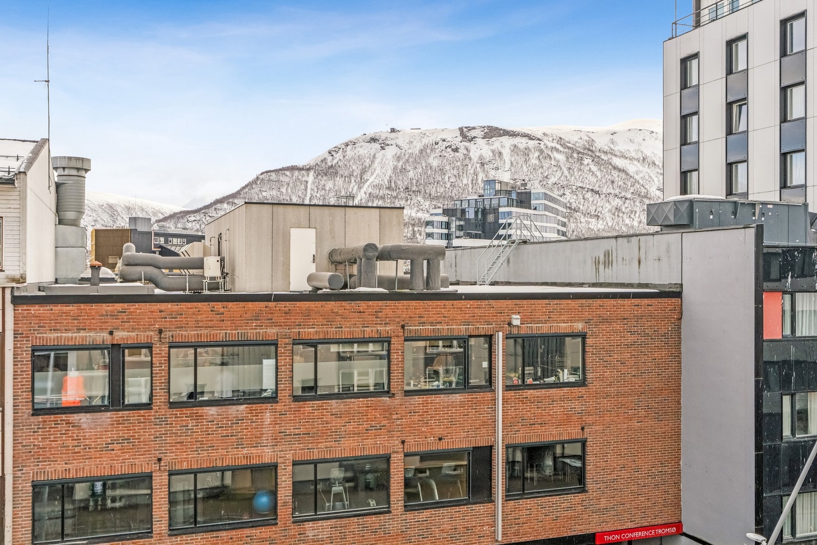 Fra leiligheten i fjerde etasje har du utsikt over byens tak og omkringliggende fjell. Galleribilde