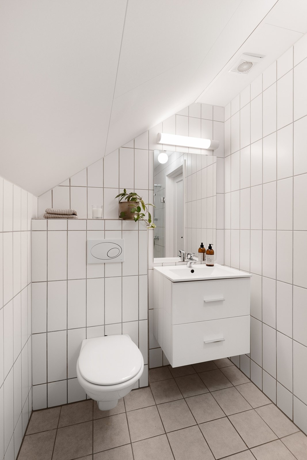 Badet er innredet med servant med underskap, speil med belysning, dusjvegger og vegghengt wc. Galleribilde