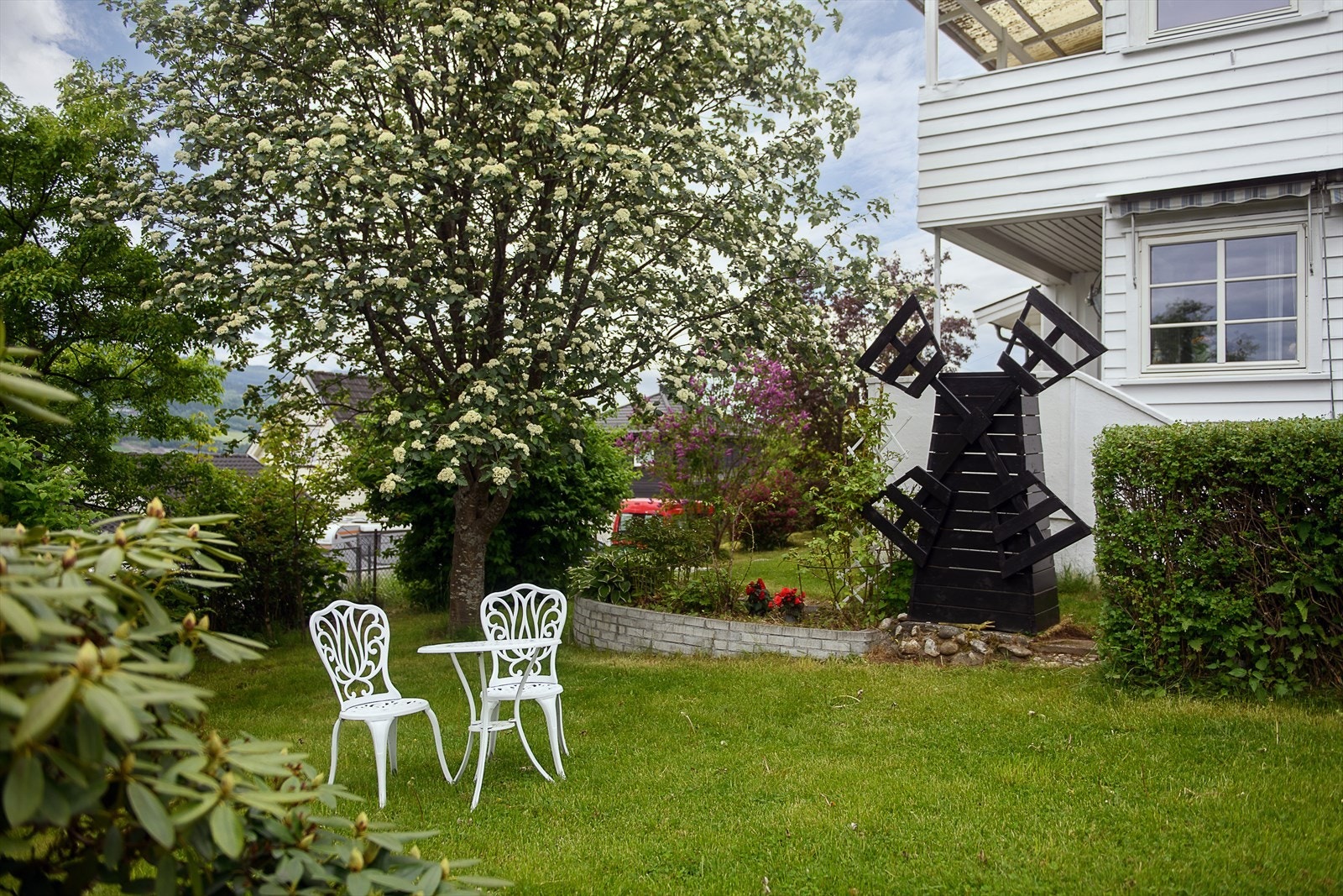 En hyggelig sitteplass i den frodige hagen. Galleribilde