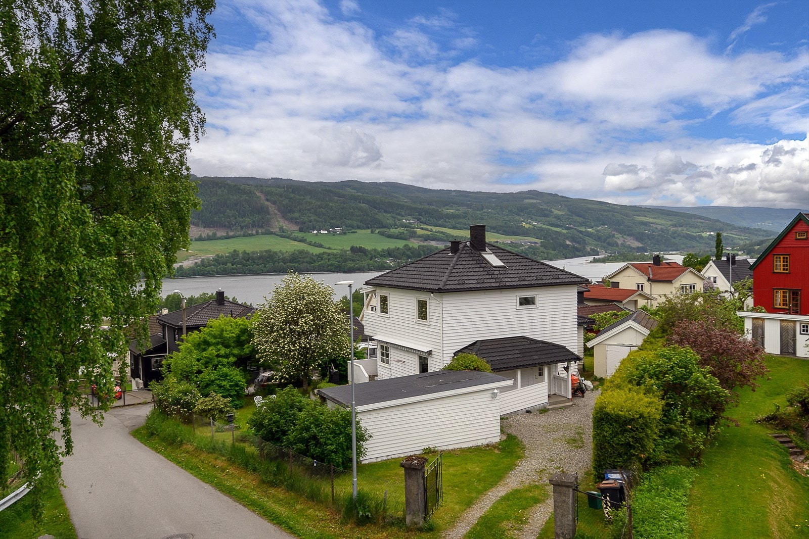 Huset ligger fint plassert og har pent opparbeidet hage og utsikt mot Mjøsa fra boligens 2. etasje. Galleribilde