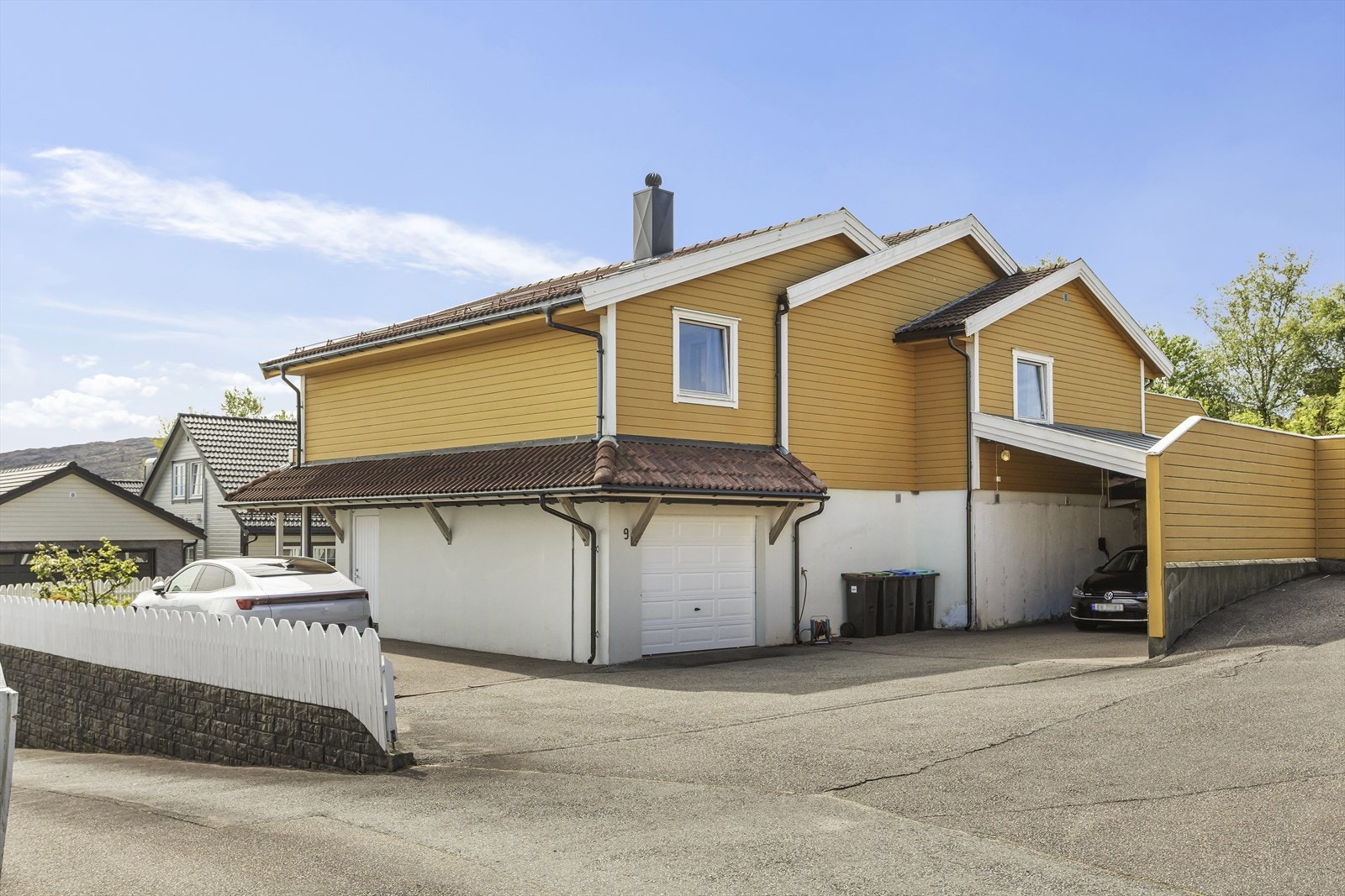 Garasje og carport med elbillader samt asfaltert parkeringsplass Galleribilde