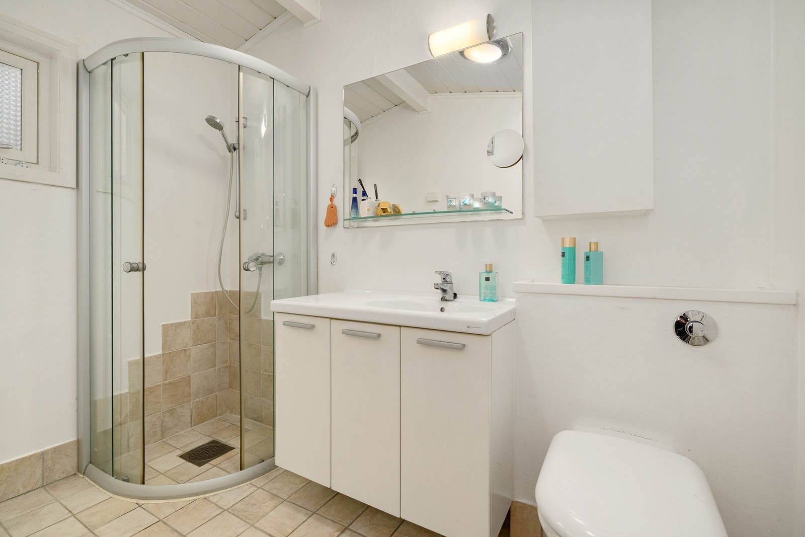 Bad med dusjhjørne, servant i seksjon og wc med innebygget cisterne. Galleribilde