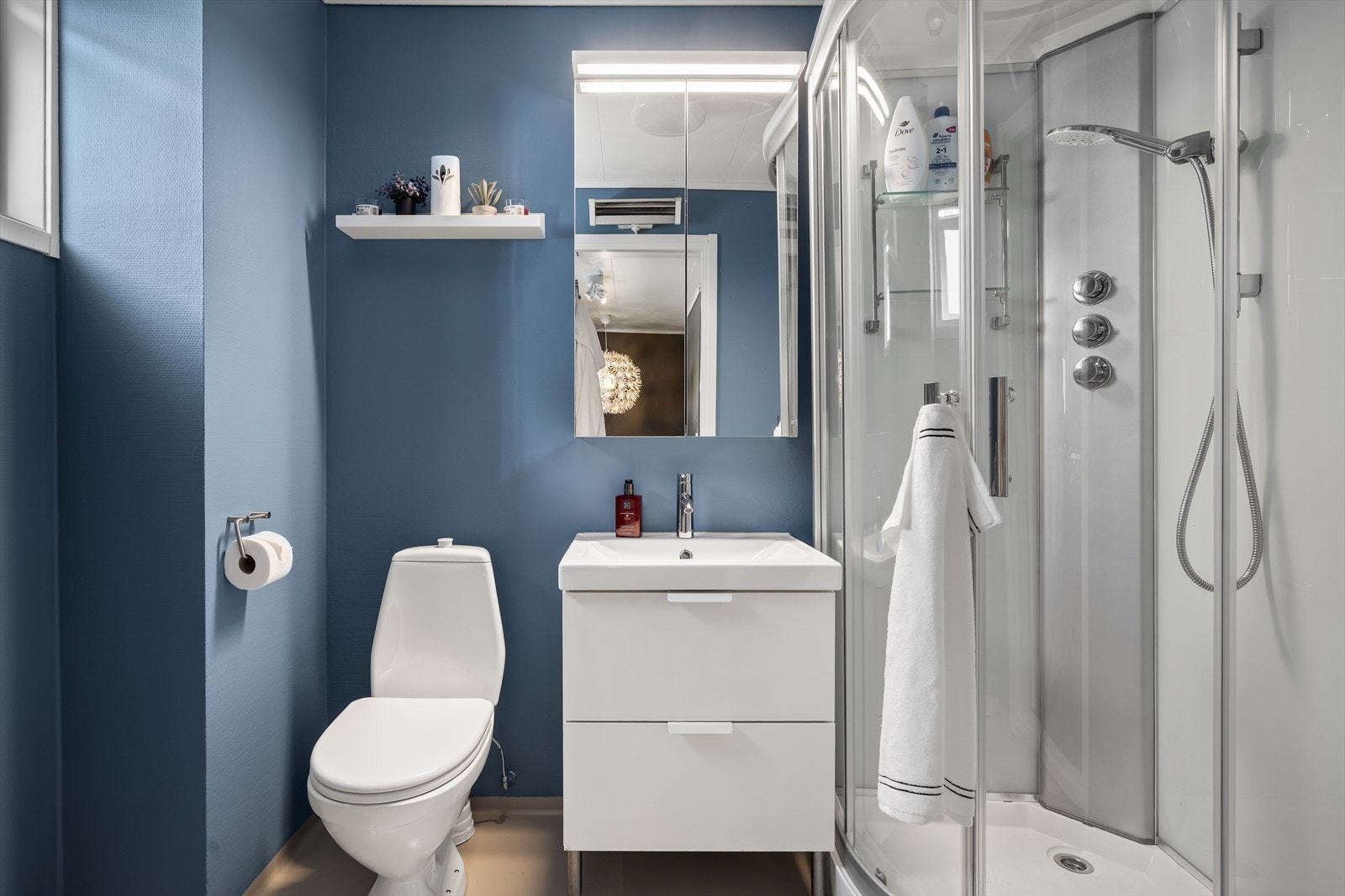 Badet ligger i boligens andre etasje og er innredet med dusjkabinett, servantskap, speilskap, toalett og opplegg for vaskemaskin. Galleribilde