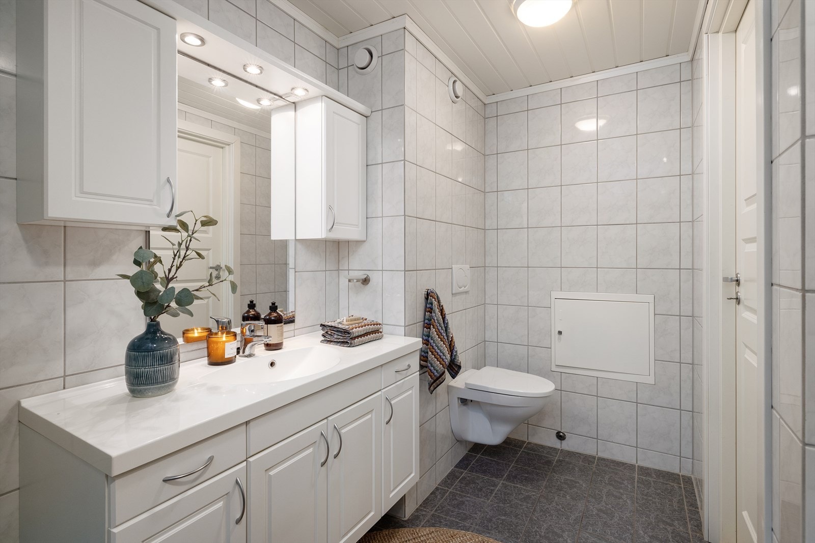 Badet har elektrisk gulvvarme, flislagte overflater og vegghengt toalett. Galleribilde