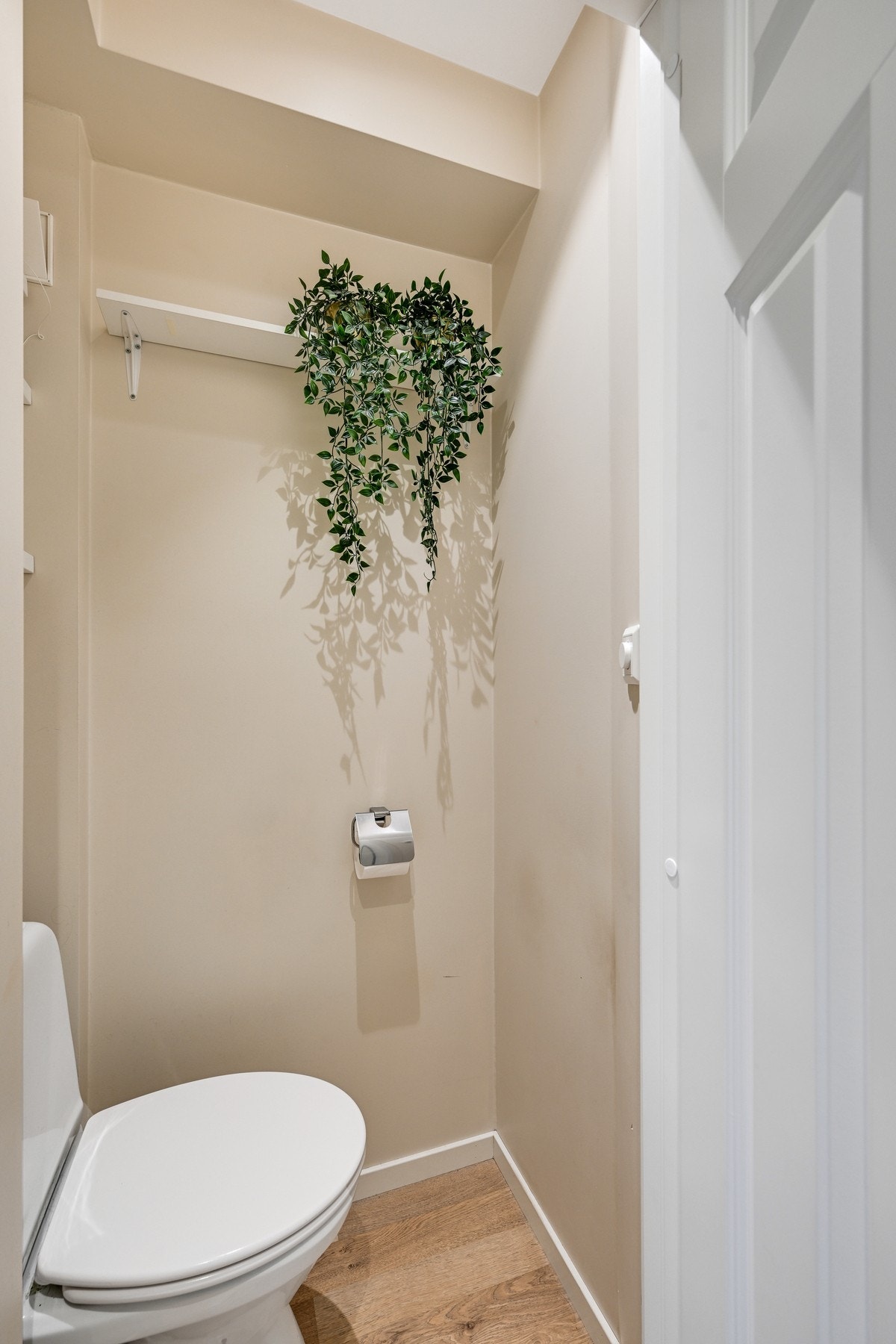 Separat toalettrom i tilknytning til badet med fine overflater Galleribilde