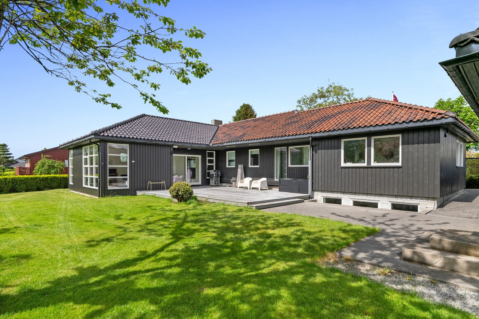 Fra oppholdsrommene er det enkel tilgang til boligens flotte uteområder med romslig terrasse og opparbeidet hage. Galleribilde