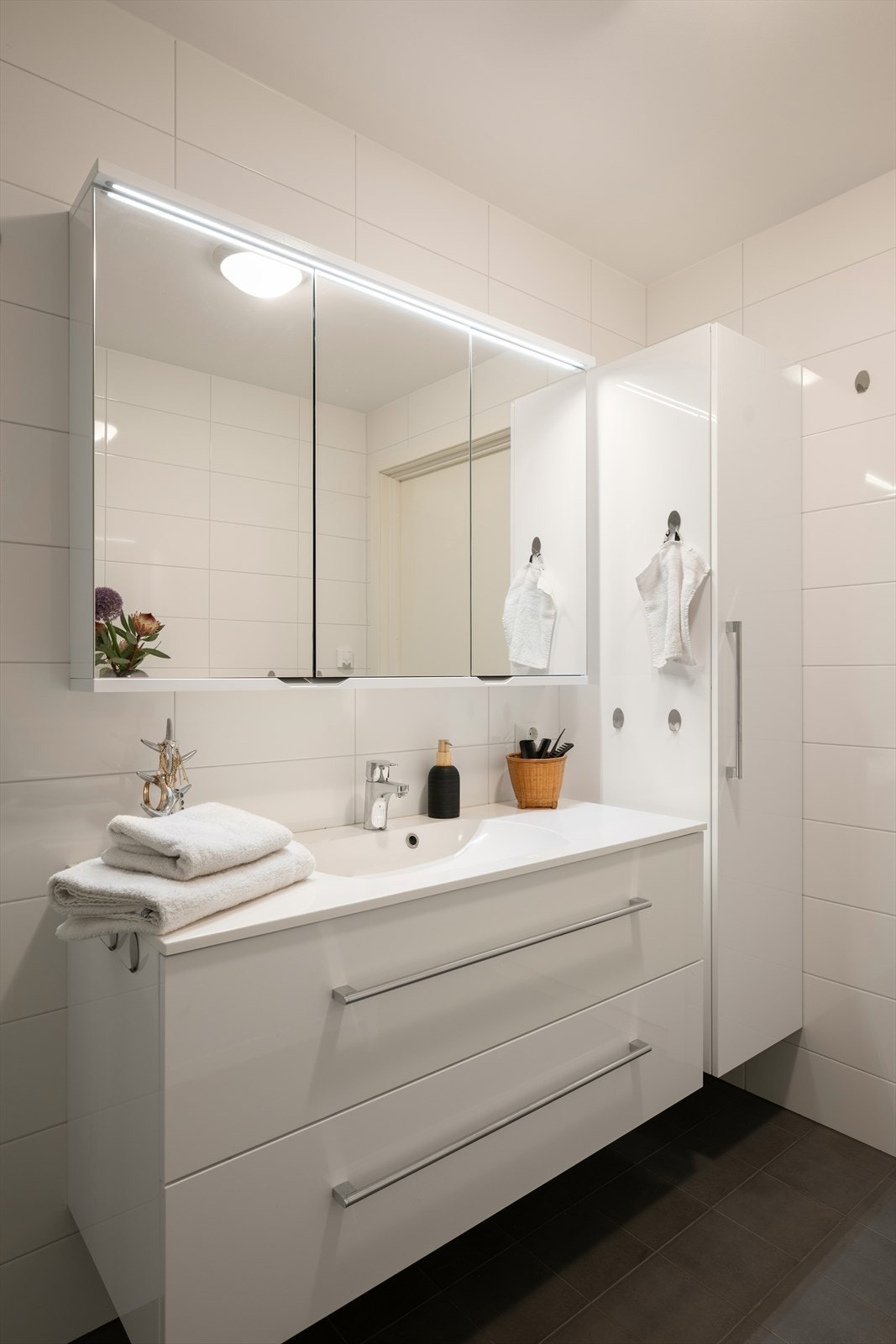 Baderomsinnredning med heldekkende servant og speilskap med belysning. Galleribilde