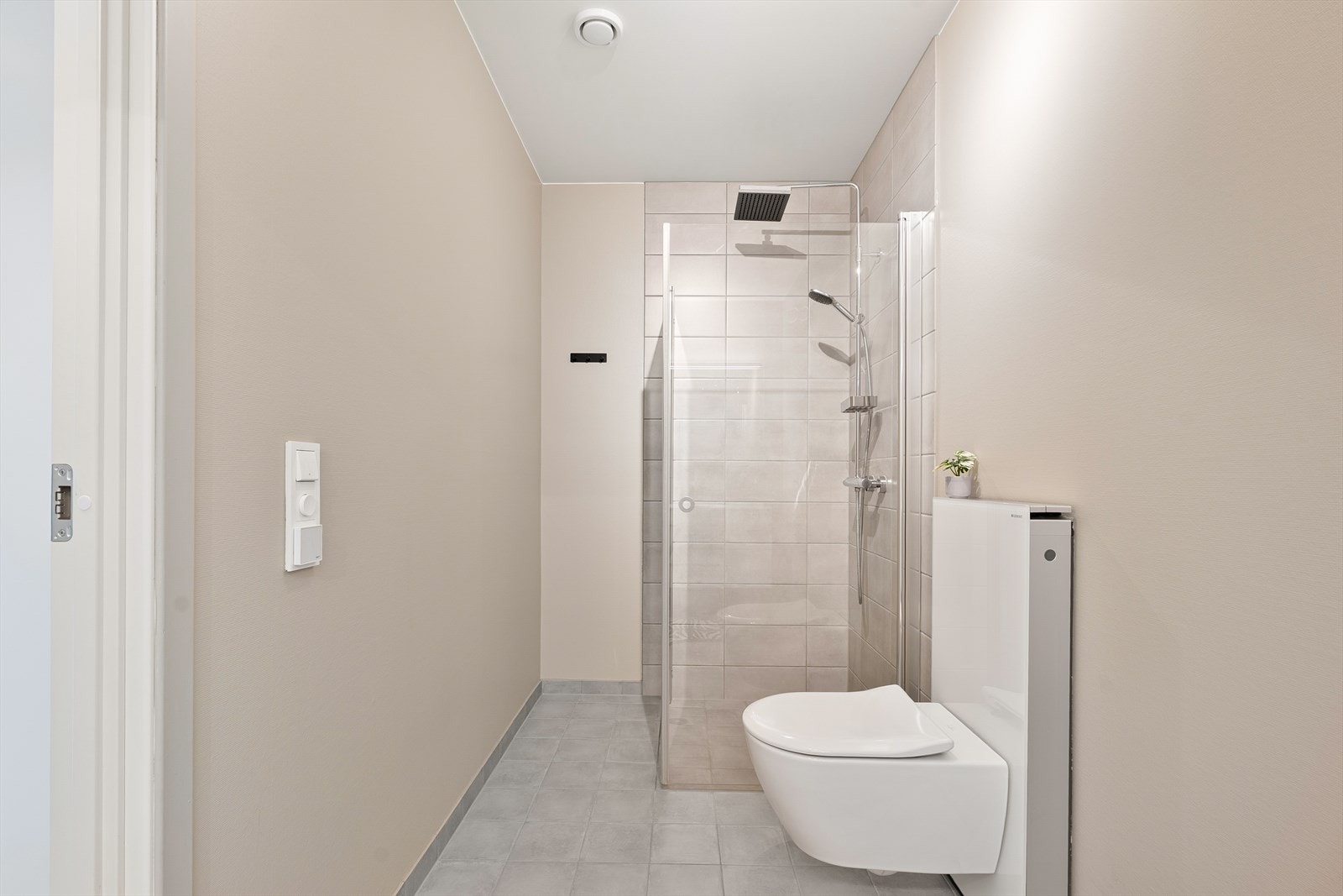 Badet i 1 etasje har nedfelt dusjhørne med innfellbare glassvegger og vegghengt toalett. Elektriske varmekabler i gulv. Galleribilde