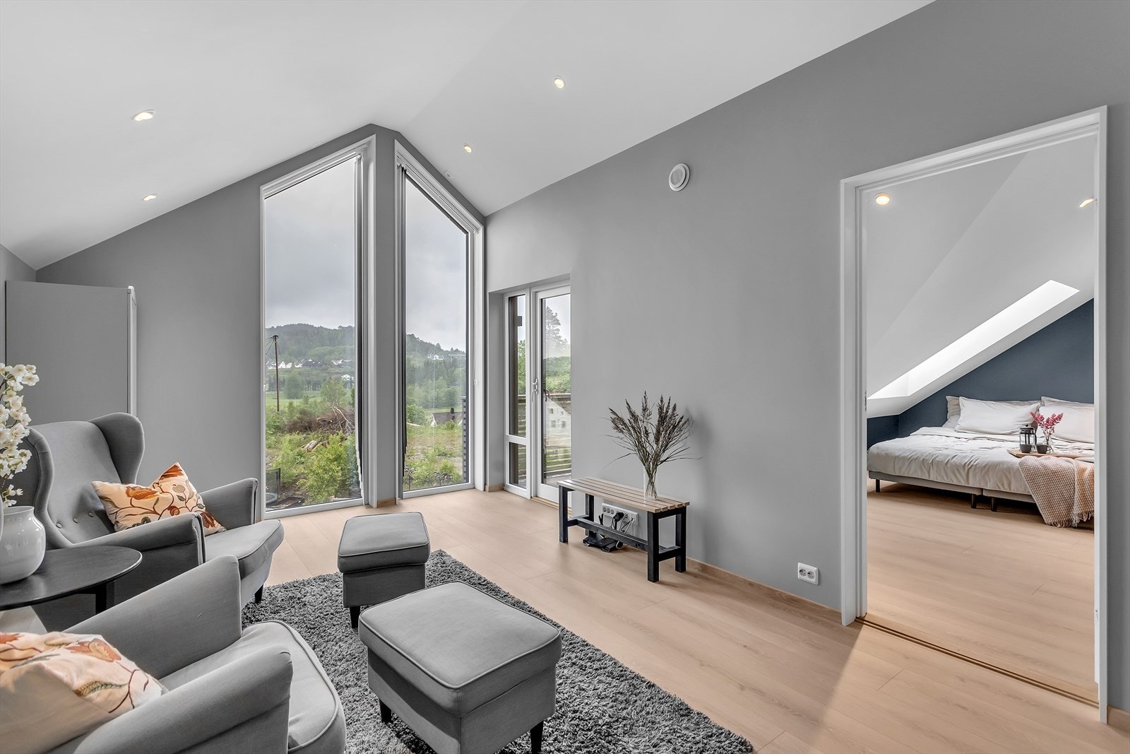Store vindusflater slipper inn rikelig med naturlig lys og byr på en luftig utsikt over nabolaget og de vakre åsene i bakgrunnen. Galleribilde