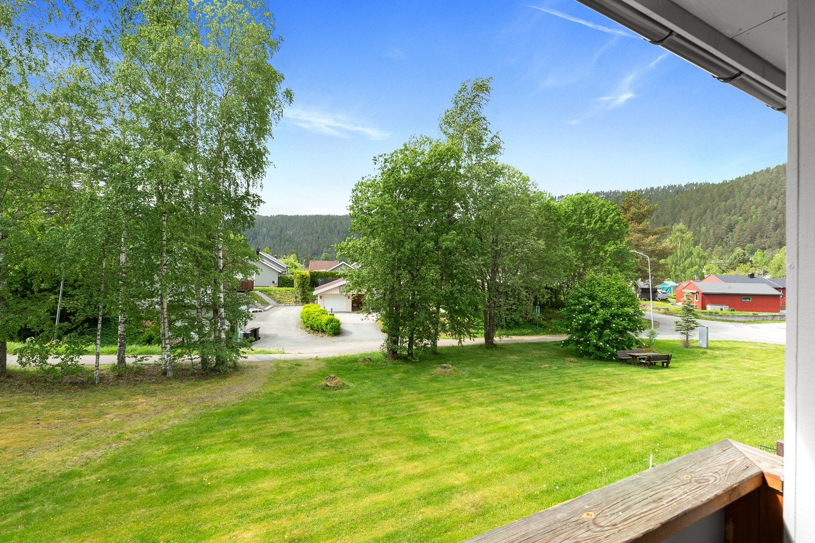 Flat tomt med plen og parkering på felles gårdsplass. Galleribilde